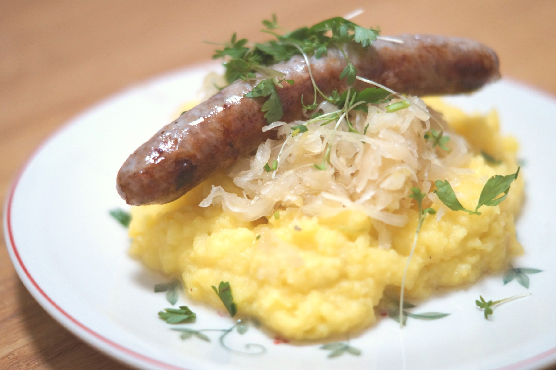 Rezeptbild für Püree mit Kürbis-Kartoffel und Kräutern an Bratwurst und Sauerkraut