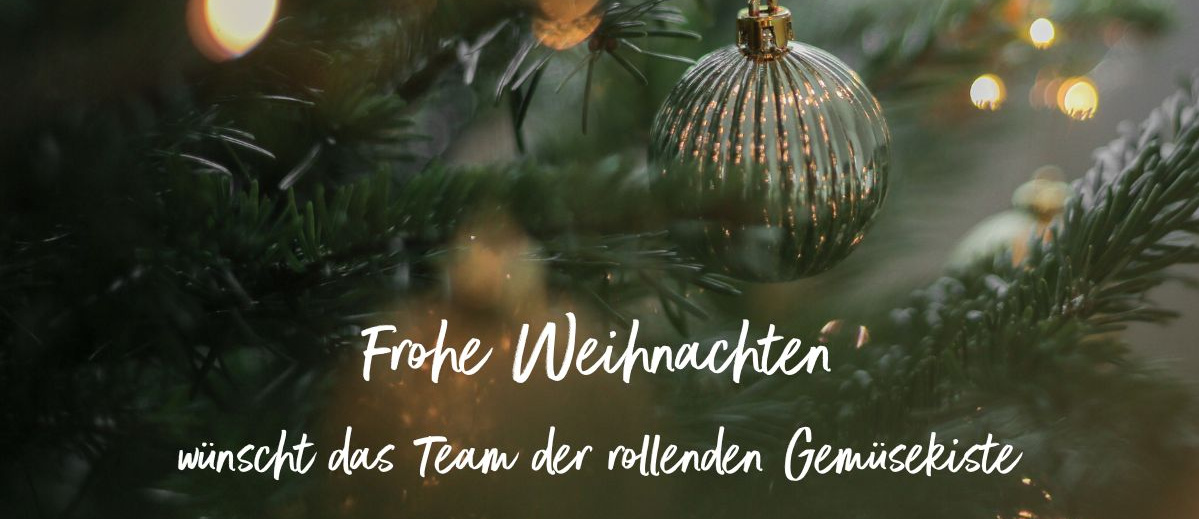 KI generiert: Das Bild zeigt einen weihnachtlich geschmückten Tannenbaum mit Lichtern und einer glänzenden Kugel. Im Vordergrund steht der Text "Frohe Weihnachten wünscht das Team der rollenden Gemüsekiste".